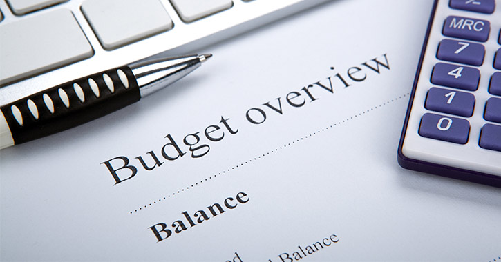 calculator, pen, and budget overview sheet