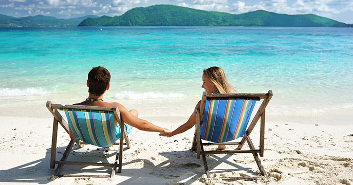 couple sitting in chairs on the beach