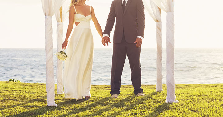 bride and groom in front of the ocean