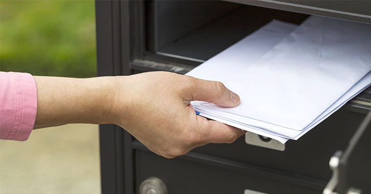 woman getting mail out of mailbox