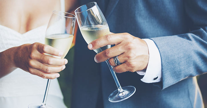 bride and groom holding champagne