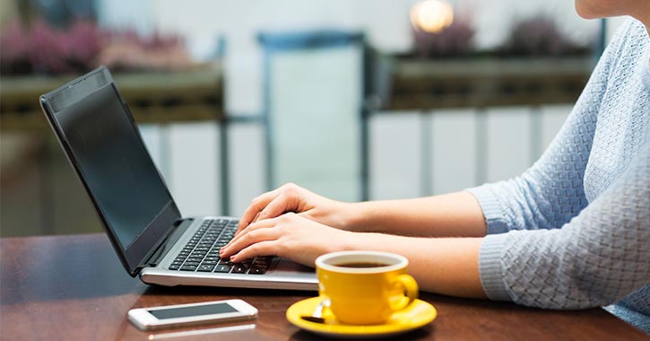 woman on laptop with cup of coffee