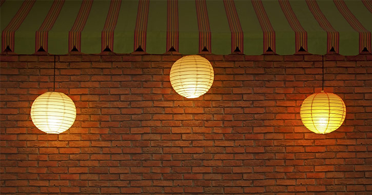 paper lanterns in front of a brick wall