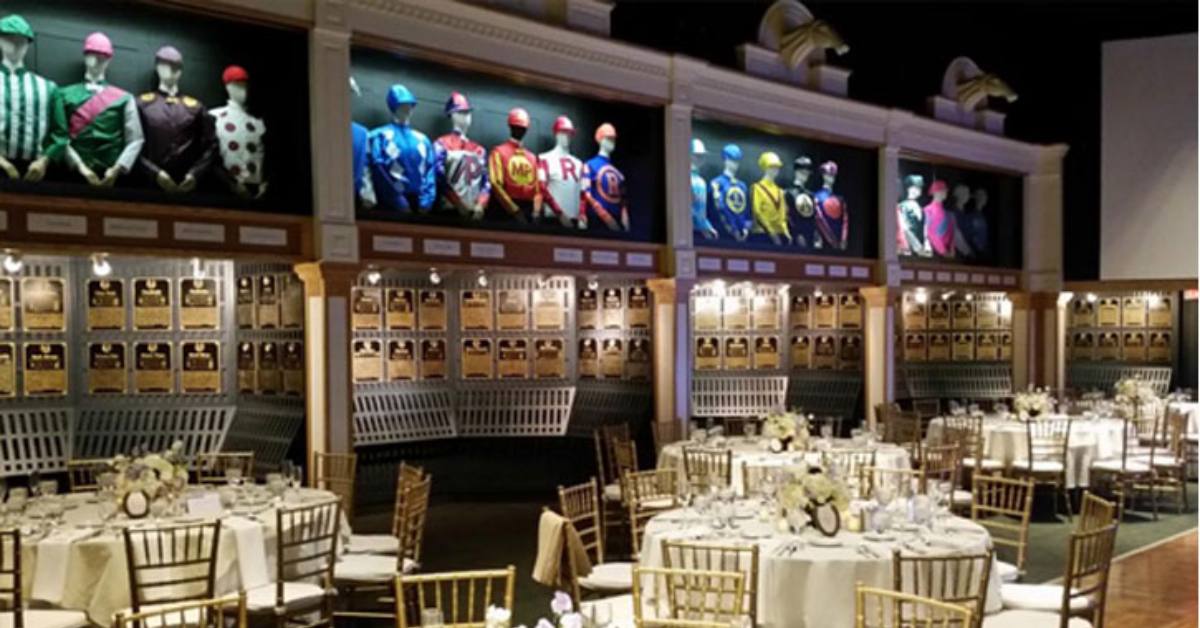 wedding reception tables and chairs set up in a room with jockey clothing on the walls