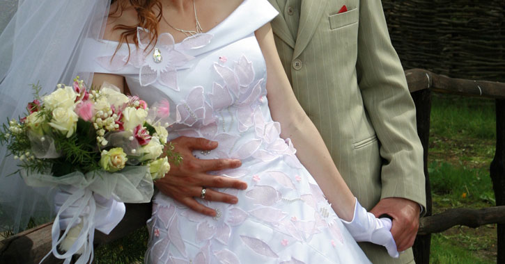 close up of a groom holding his bride