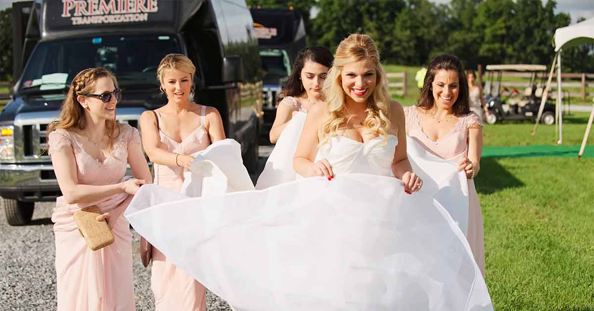 Bridesmaids help a bride with her dress before a wedding.