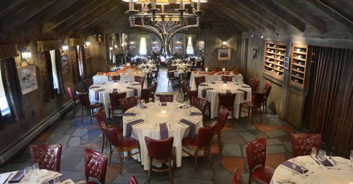 dining room with white tableclothed tables and flagstone floors