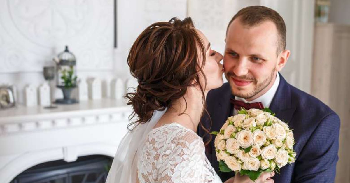 bride kissing the cheek of a smiing groom