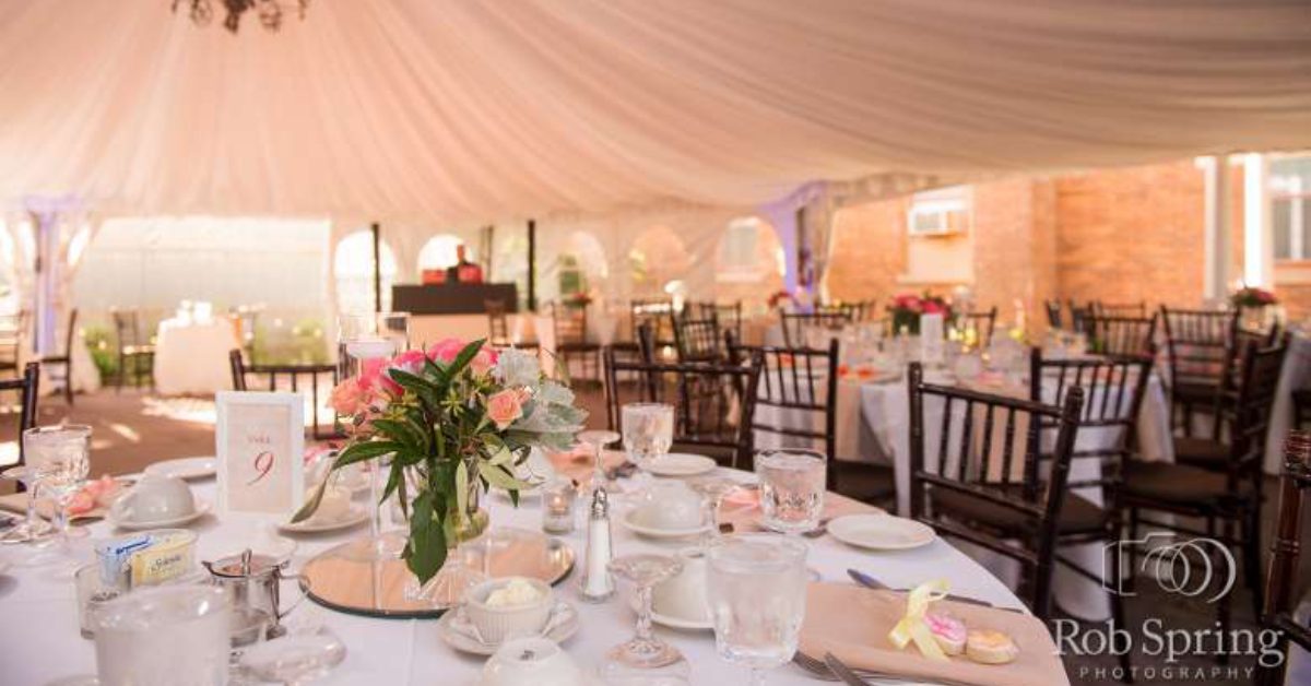beautiful reception tent with tablecloths and a chandelier